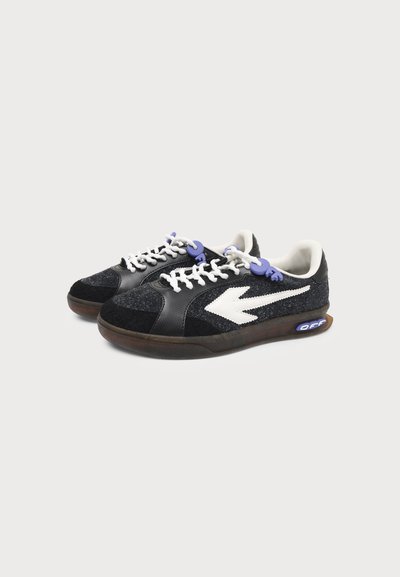 Paire de baskets basses noires avec logo flèche blanc, lacets blancs, bloqueurs de lacets violets et semelles translucides avec texte "OFF".