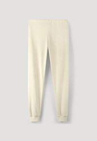 Ljust beige joggers i mjukt tyg, med resår i midjan och elastiska muddar vid anklarna. Slät yta, inga mönster.
