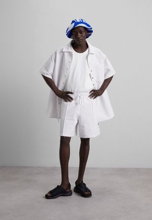 Nikolaj Storm CYRUS PIN UNISEX - Tepláky - white