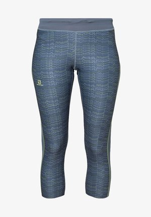 Mallas hechas de tela elástica, con un patrón ondulado en azul oscuro con acentos verdes, y una cinturilla alta para un ajuste seguro.