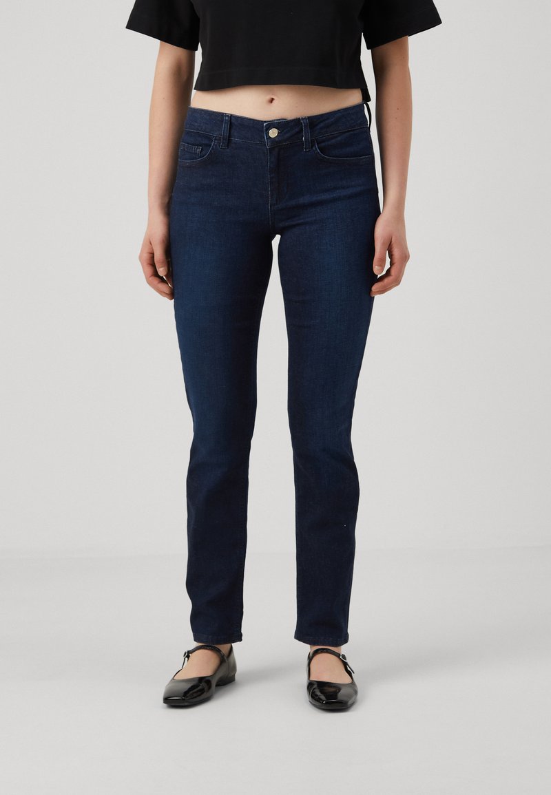 Tummansiniset skinny-farkut, joissa on keskitason vyötärö, nappikiinnitys ja kaksi etutaskua. Sujuva, joustava denimkangas puhtaalla viimeistelyllä.