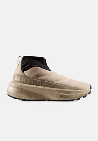 Μπεζ sneaker Mammut τύπου slip-on με παχύ πέδιλο με κηλίδες, μαύρο ελαστικό κολάρο στον αστράγαλο και υφασμένο επάνω μέρος, εμφανίζεται από το πλάι σε λευκό φόντο.