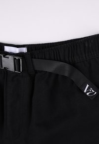 Schwarze Shorts mit elastischem Bund, einem schwarzen verstellbaren Riemen und einem kleinen Etikett mit "VZ"-Logo an der Seite.