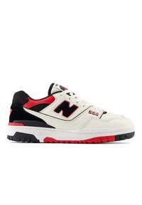 Les baskets New Balance 550 présentent un dessus en cuir crème avec des accents noirs et rouges, des détails perforés, et une semelle en caoutchouc grise et rouge.