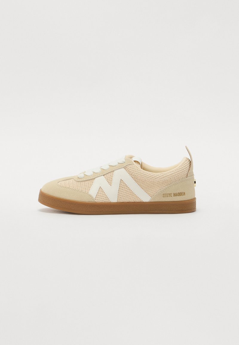 Sneaker beige con tomaia in maglia testurizzata, dettagli in gomma bianca e suola in gomma marrone. Presenta un design con lacci e il logo sul tallone.