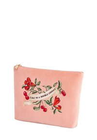 Vaaleanpunainen mokkasuojus, jossa on brodeerattu kukkakuosi, jossa on punaisia kukkia ja kirsikoita. Mukana teksti "TYKKÄÄ KAKSOISKIRSIKASTA."