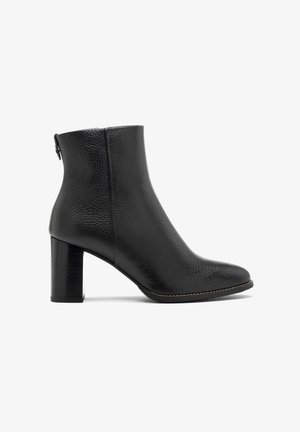 Czarne skórzane botki za kostkę o teksturowanym wykończeniu, z okrągłym noskiem i masywnym obcasem. Z tyłu znajduje się zamek błyskawiczny, co ułatwia zakładanie.