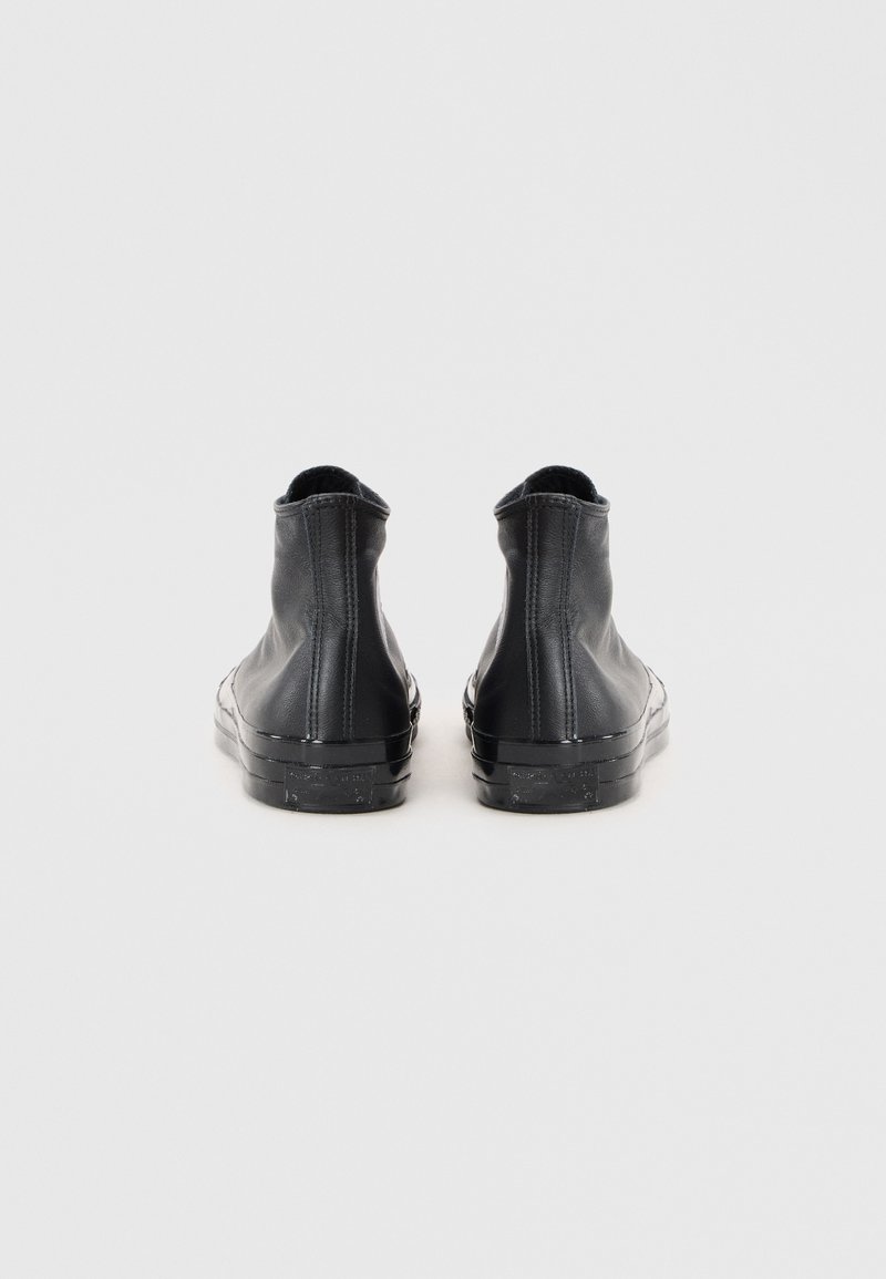 Schwarze Leder-Ankle-Boots mit glatter Textur, runder Spitze und minimalistischem Design. Sie verfügen über eine Gummisohle und dezente Stichakzente.