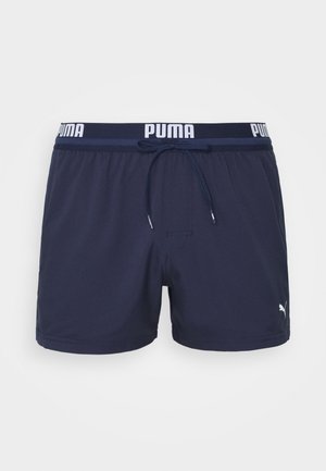 Marinefarbene Schwimmshorts mit elastischem Bund, verfügen über ein weißes "PUMA"-Logo, einen Kordelzug und eine glatte Stoffoberfläche.