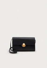 Black leather crossbody bag with a flat design, gold hardware accent, and a flap closure. Features a detachable strap for versatility.