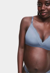Sostén de maternidad azul claro con borde de encaje, diseño de escote en V, tirantes ajustables y textura suave. Cuenta con un estilo sin relleno y sin aros.