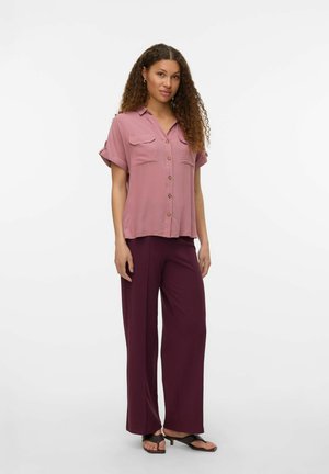 Lys pink kortærmet skjorte med knapper og to brystlommer, parret med maroon løstsiddende bukser og sorte klipklappere.