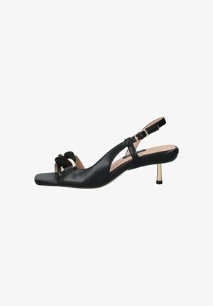 Scarpa slingback in pelle nera con punta scoperta, accenti dorati e un dettaglio a fiocco testurizzato. Il tacco è un sottile stiletto in metallo dorato.