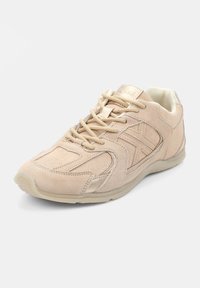 Baskets en suède beige avec des accents texturés, bout arrondi et lacets plats. Elles comportent une semelle légère et des éléments de design subtils.