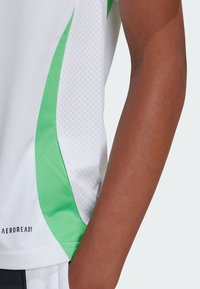 Mannen sportshirt met een witte body en groene, gestructureerde zijpanelen. Gemaakt van ademende stof, met "AEROREADY" op de zoom.