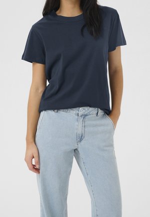 Navyblå bomuld T-shirt med korte ærmer og rund hals, kombineret med lyseblå, højtaljede jeans med løs pasform.