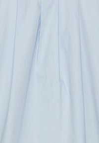 Abito in cotone azzurro chiaro con design plissettato, caratterizzato da una texture liscia e un leggero lucido, progettato per una vestibilità comoda.