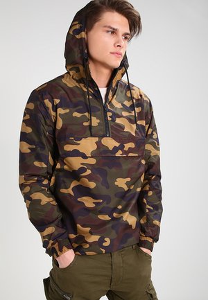Camouflage pullover jacket with a hood, featuring a half-zip front, elastic cuffs, and a blend of green, brown, and beige colors.