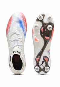 Fußballschuhe aus weißem Mesh mit roten und blauen Farbverlauf-Mustern, ausgestattet mit Schnürverschluss, runden Stollen und einem schwarzen Logo auf der Zunge.