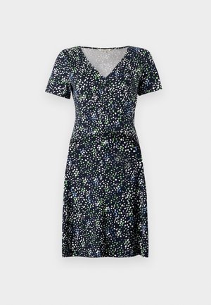 Īsām piedurknēm tērps tumši zilā krāsā ar daudzkrāsainu punktotu rakstu. Tam ir V veida kakla izgriezums un pielāgota josta, izgatavots no viegla auduma.