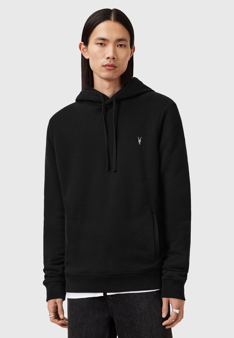 Haut à capuche noir en tissu doux, doté d'une poche kangourou à l'avant, de cordons de serrage et d'un petit logo en argent sur la poitrine gauche.