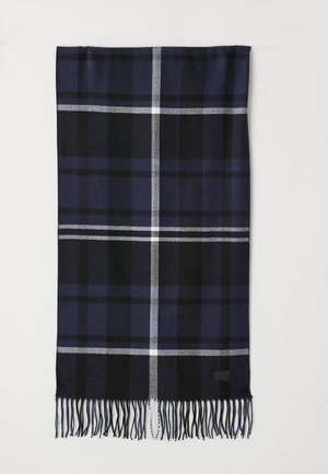 Écharpe à carreaux bleu marine avec des accents noir et blanc, bords frangés, fabriquée en tissu doux, arborant un motif à carreaux prononcé.