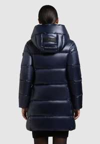 Chaqueta acolchada en azul marino con acabado brillante, que cuenta con una gran capucha, diseño acolchado y parche de marca en la parte posterior.