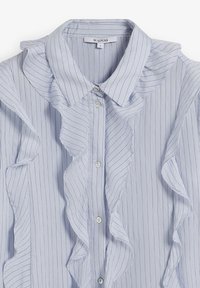 Light blue striped shirt featuring a ruffled front, pointed collar, and button closure. Made from a soft fabric with a smooth texture.