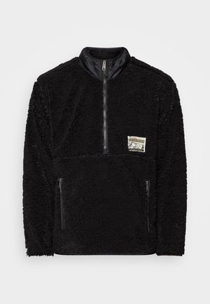 Czarna bluza polarowa z zamkiem na ćwierć długości, stójką, dwoma kieszeniami zamykanymi na zamek oraz małą prostokątną naszywką z logo Levi's Warm na piersi.