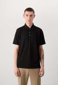 Černé polo tričko s klasickým límcem, krátkými rukávy a zapínáním na tři knoflíky. Vyrobeno z hladkého materiálu s jemnými vertikálními pruhy.