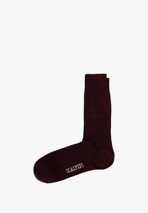 Calcetines burdeos acanalados con una textura suave, que presentan un logotipo de marca contrastante en blanco en la zona del tobillo. Diseño de longitud completa.