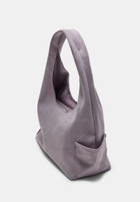 Fioletowa torebka zamszowa o luźnym kształcie, z zakrzywionym uchwytem i małą boczną kieszenią. Gładka tekstura i minimalistyczny design.