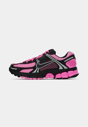 Sapatilha desportiva preta e rosa com parte superior em malha, riscas refletoras, logótipo da Nike, sola almofadada e calcanhar texturizado para suporte.