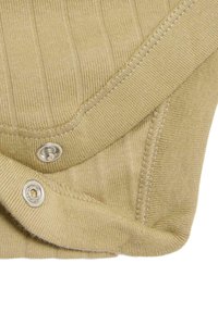 Tessuto khaki a coste con bottoni a pressione in fondo e nelle cuciture delle spalle; texture morbida con dettagli di cucitura visibili in tutto il capo.