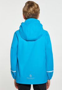 Vattentät blå regnjacka med huva, elastiska ärmslut och reflexdetaljer. Slät yta och logotypdetalj nära fållen.