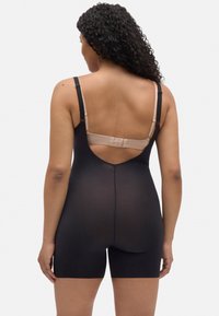 Bodies moldeador negro con tirantes ajustables y diseño de espalda baja. Tejido suave con un acabado mate, que se extiende hasta la mitad del muslo.