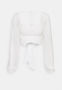 Blouse blanche courte avec manches longues, corsage plissé et fermeture à nouer à la taille. Tissu lisse et léger avec un léger éclat.