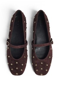 Chaussures Mary Jane en suède bordeaux avec un bout arrondi, un talon plat et des clous dorés sur le dessus. Comprend une sangle réglable.