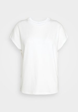 Valkoinen lyhythihainen t-paita pehmeää puuvillaa, pyöreällä pääntiellä ja rennolla istuvuudella, jossa kauluksen kohdalla hienovarainen ompeludetalji.