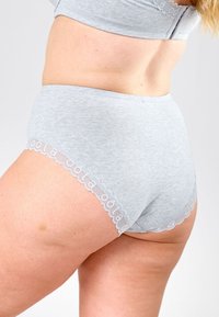 Harmaat puuvillaiset korkeavyötäröiset alushousut, joissa on aaltoilevat pitsireunat ja toistuva brändinimi-kuvio vyötäröllä.