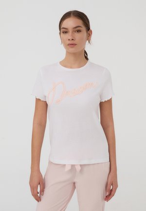 T-shirt bianco in cotone con maniche corte e scallop, con la scritta ricamata "Dream" in rosa sul davanti. Texture liscia, vestibilità rilassata.