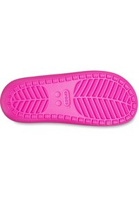 Suola di Crocs di colore rosa brillante con un motivo di battistrada testurizzato simile a foglie e logo Crocs al centro su uno sfondo bianco.