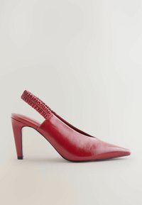 Rdeče usnjene slingback ženske čevlje s koničastim nosom, elastičnim nabranim traknikom in stožčasto peto. Gladka tekstura in eleganten dizajn.