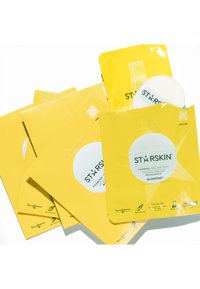 Emballage jaune pour les puffs à peeling moussant STARSKIN, présentés avec un puff blanc rond et des accents en forme d'étoile. Différentes conceptions affichées.