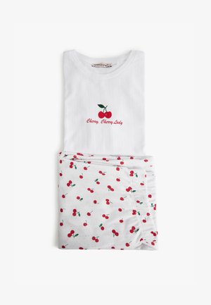 Ensemble en coton blanc avec texture côtelée ; le haut présente une broderie de cerises rouges et le texte "Cerise, Cerise Dame" ; le bas a un fond blanc avec un motif de cerises.