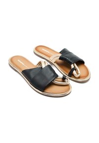 Sandalias deslizantes de cuero negro con una tira cruzada acolchada y una suela beige bordeada en dorado. La plantilla es marrón, ofreciendo un contraste con la parte superior.