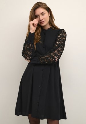 Black button-up dress made of soft fabric, featuring long lace sleeves with floral patterns and a flare design, providing a loose fit.