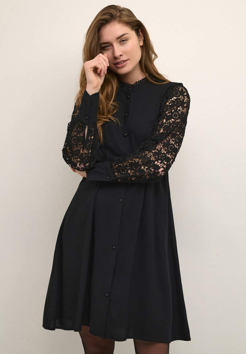 Black button-up dress made of soft fabric, featuring long lace sleeves with floral patterns and a flare design, providing a loose fit.