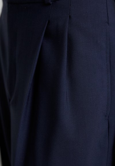Dark navy tailored trousers featuring a smooth fabric, pleated front, and precise stitching, showcasing a clean, structured design.