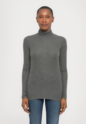 Maglione a collo alto grigio scuro realizzato in morbido tessuto, con maniche lunghe e orlo curvo, indossato con jeans blu.